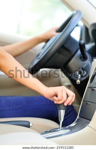 woman
driver shifting the gear stick and driving a
car