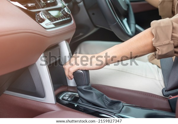 woman driver stick shift\
transmission a car gear, hand controlling steering wheel during\
vehicle moving. Journey, trip and safety Transportation\
concepts