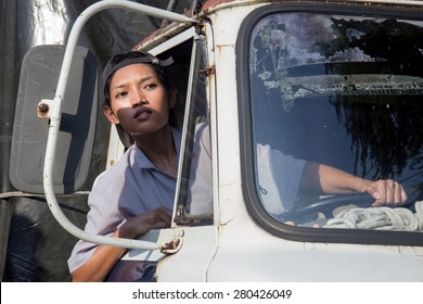 Woman Driver In The Truck Looking Out From Window. Asian Girl Driving A Old Used Lorry. 