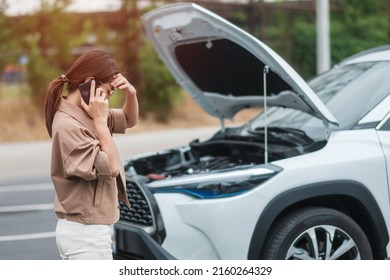 woman driver using mobile phone during problem car. Breakdown or broken car on road. Vehicle Insurance, maintenance and service concept - Powered by Shutterstock