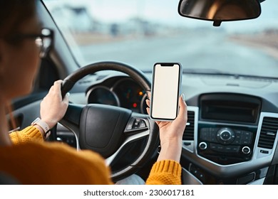 Woman driver using mobile phone screen blank mockup while driving distracted from the road. - Powered by Shutterstock