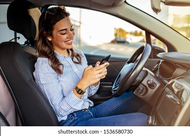 Woman Driver Using A Smart Phone In Car. Woman Driver Using A Smart Phone In Car. Leisure, Road Trip, Technology, Travel And People Concept - Happy Woman Driving Car With Smarhphone