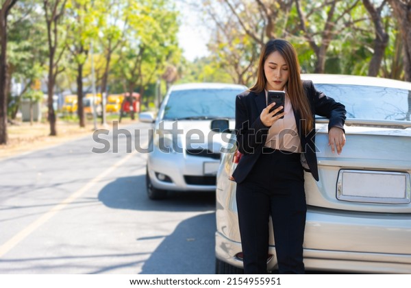 Woman drivers call insurance after a car\
accident before taking pictures and sending insurance. Online car\
accident insurance claim idea after submitting photos and evidence\
to an insurance company.