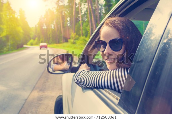 A woman\
drives a car and looks back out the\
window