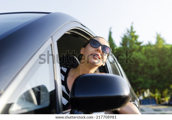 Woman drives a car on the road\
