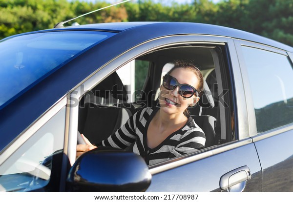 Woman drives a car on the road\
