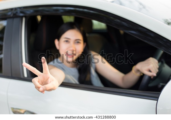 Woman drives a car and\
smiling