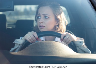 Woman drives her car for the first time, tries to avoid a car accident, is very nervous and scared, worries, clings tightly to the wheel. Inexperienced driver in stress and confusion after an accident - Powered by Shutterstock