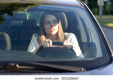 Woman drives her car for the first time, tries to avoid a car accident, is very nervous and scared, worries, clings tightly to the wheel. Inexperienced driver in stress and confusion after an accident - Shutterstock ID 2012206667