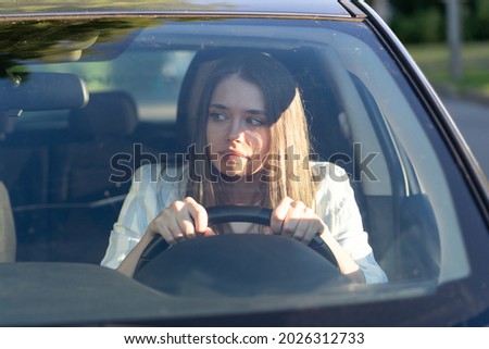 Woman drives her car for the first time, tries to avoid a car accident, is very nervous and scared, worries, clings tightly to the wheel. Inexperienced driver in stress and confusion after an accident
