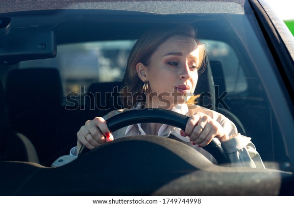 Woman drives her car for the first time, tries\
to avoid a car accident, is very nervous and scared, worries,\
clings tightly to the wheel. Inexperienced driver in stress and\
confusion after an\
accident