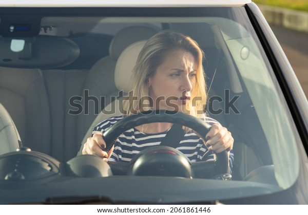 Woman drives her car for the first time, tries\
to avoid a car accident, is very nervous and scared, worries,\
clings tightly to the wheel. Inexperienced driver in stress and\
confusion after an\
accident