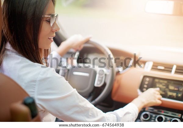 Woman drives luxury\
car on ideal roads    