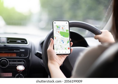 a woman driving a black car Use your smartphone to view a map showing your travel route. and use the application to get to the destination It's on the highway road.