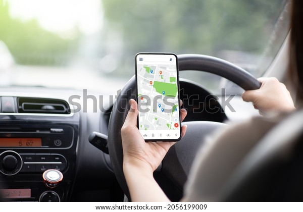 a woman driving a\
black car Use your smartphone to view a map showing your travel\
route. and use the application to get to the destination It\'s on\
the highway road.