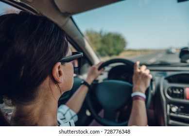 Woman Driving Car During The Day And Holding Two Hands On A Steering Wheel