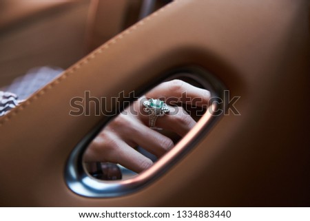 Woman driving car, Hand hold steering wheel. Close-up of female hands with beautiful diamond ring on steering wheel of super car