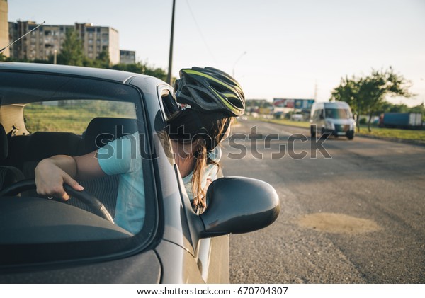 woman driving car in helmet with horror on her\
face, learning driving