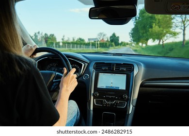 Woman driving car on country road at sunset. Back view of female driver in vehicle - Powered by Shutterstock