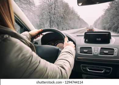 Woman Driving The Car On Snowy Road