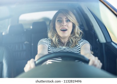 The woman driving the car in a panic. The lady urgently brakes in the car or grabbed the wheel frightened.