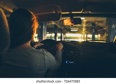 Woman Driving Car In Parking On Sunset Looking For Spot