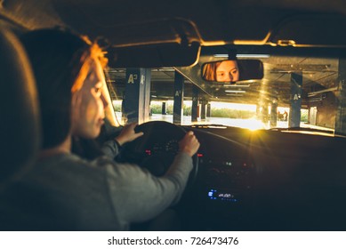 Woman Driving Car In Parking On Sunset Looking For Spot