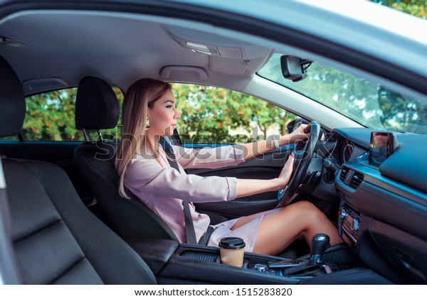 Woman driving car,\
presses signal button on steering wheel, stop abrupt stop. An alarm\
is danger of braking, in pink suit in car, in summer in city,\
business lady going to\
meet