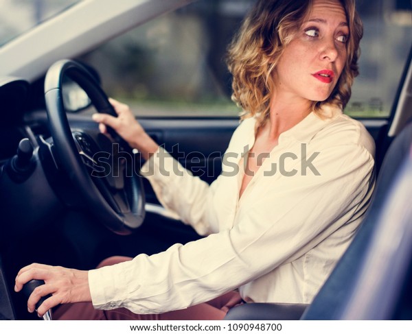 Woman driving a car in\
reverse