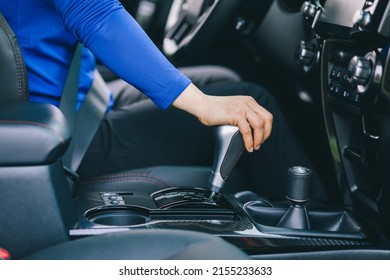 Woman driving car shifting the gears - Shutterstock ID 2155233633