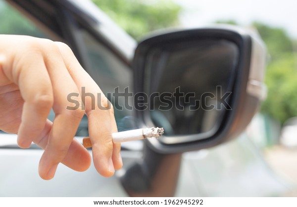 Woman driving a
car smokes, focus on
cigarettes