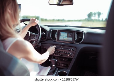 Woman Driving Car, Summer Outside City, Increases Volume On Radio, Touch Screen, Automatic Transmission, Radio Station Selection, Mechanical Adjustment Of Air Conditioner Level