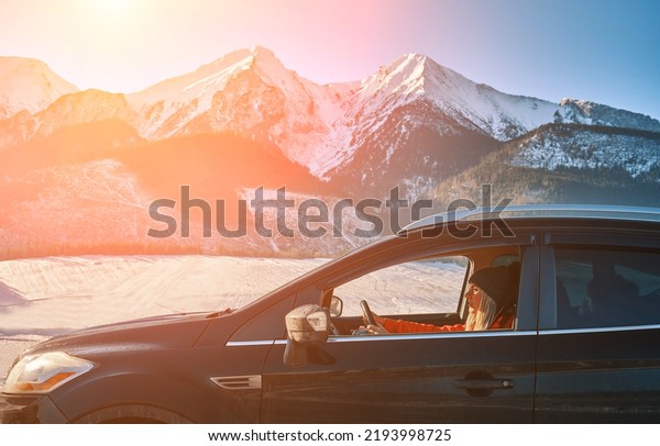 Woman driving a car in sunny day, travel in the\
mountains, freedom and active, Traveling, exploring, enjoying the\
view of the mountains, landscape, lifestyle concept winter vacation\
outdoors.