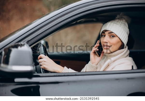 Woman driving in car and\
using phone