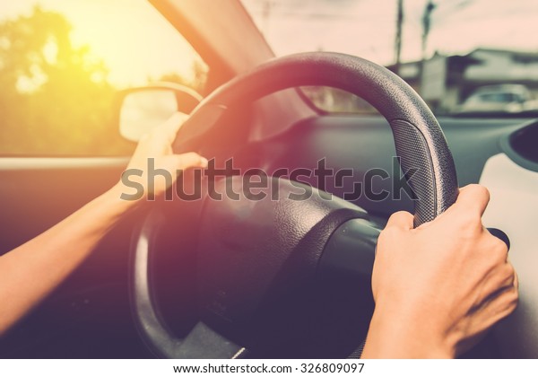 Woman driving car\
in vintage filter effect.