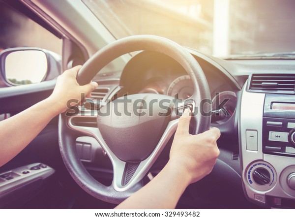 Woman driving car with\
vintage filter.