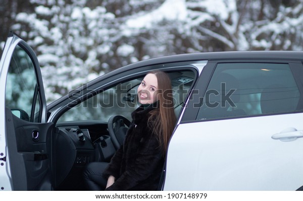 A woman driving a car in winter. Winter car driving\
by a woman