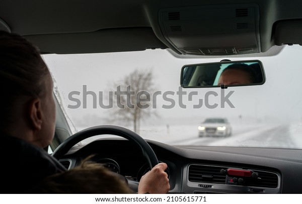 Woman driving a car in\
winter time.