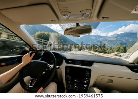 Woman driving her new car with destination Servoz, the location of the tunnel of Mont-Blanc beautiful montain range in the background