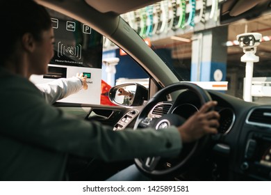 Woman Is Driving Into A Parking Garage And Is Collecting Ticket From Car Park Machine