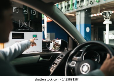 Woman Is Driving Into A Parking Garage And Is Collecting Ticket From Car Park Machine