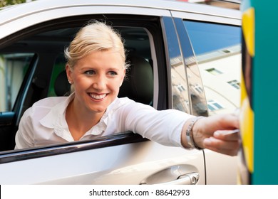 Woman Is Driving Into A Parking Garage And Is Slipping The Ticket Into The Barrier Of The Garage