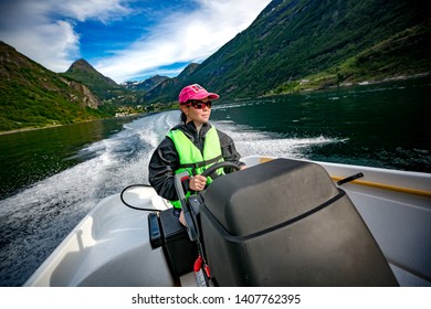 Woman Driving A Motor Boat. Geiranger Fjord, Beautiful Nature Norway.Summer Vacation. Geiranger Fjord, A UNESCO World Heritage Site.