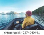 Woman Driving Motor Boat at Sunset in Coastal British Columbia in Nature Landscape Near Bute, Toba Inlet and Campbell River. Whale Watching Tourist Travel Destination, Canada