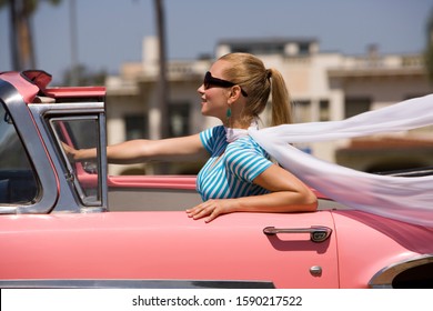 Woman driving old fashioned convertible car