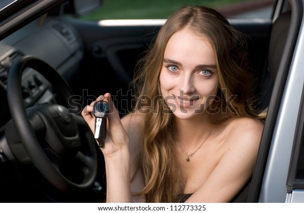 Woman\
driving showing car keys sitting in the\
auto