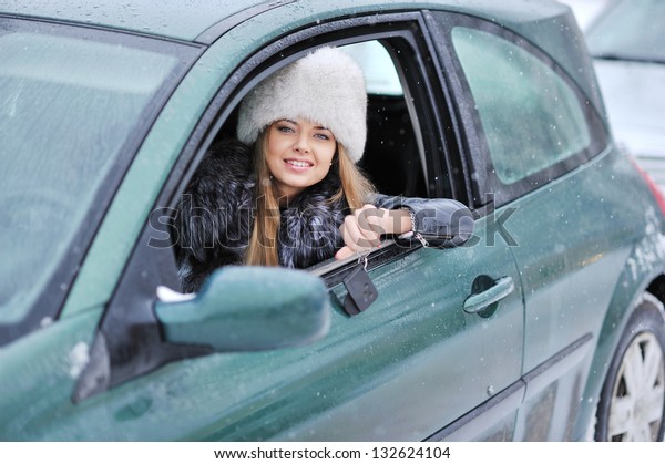 Woman driving\
showing car keys out the\
window