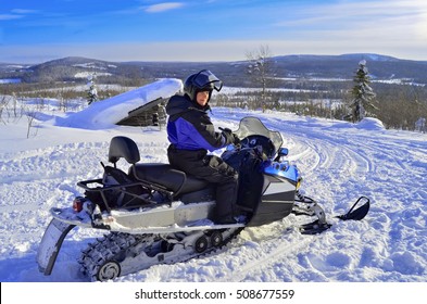 Woman Driving Snowmobile In Lapland Finland