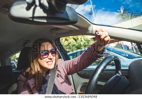 Woman driving and talking on cell phone at the\
same time. Girl in car talking on mobile phone putting people\'s\
lives in danger