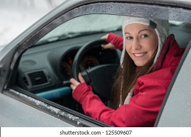 Woman Driving In Winter On Snow Covered Slippery Road In Forest